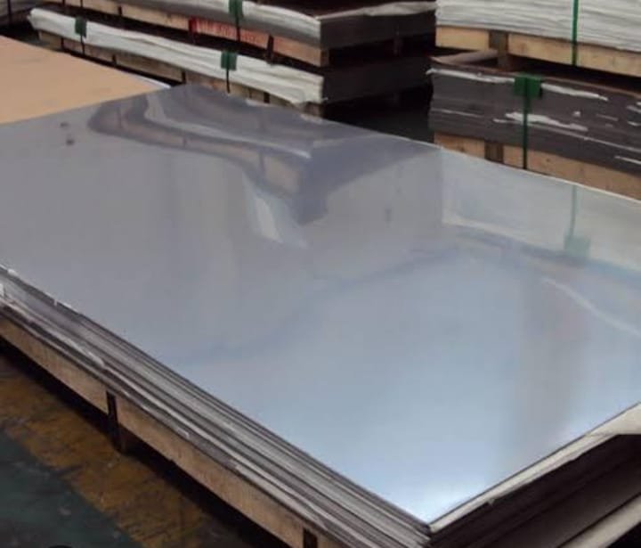 Lembaran plat stainless steel tersusun di atas palet kayu